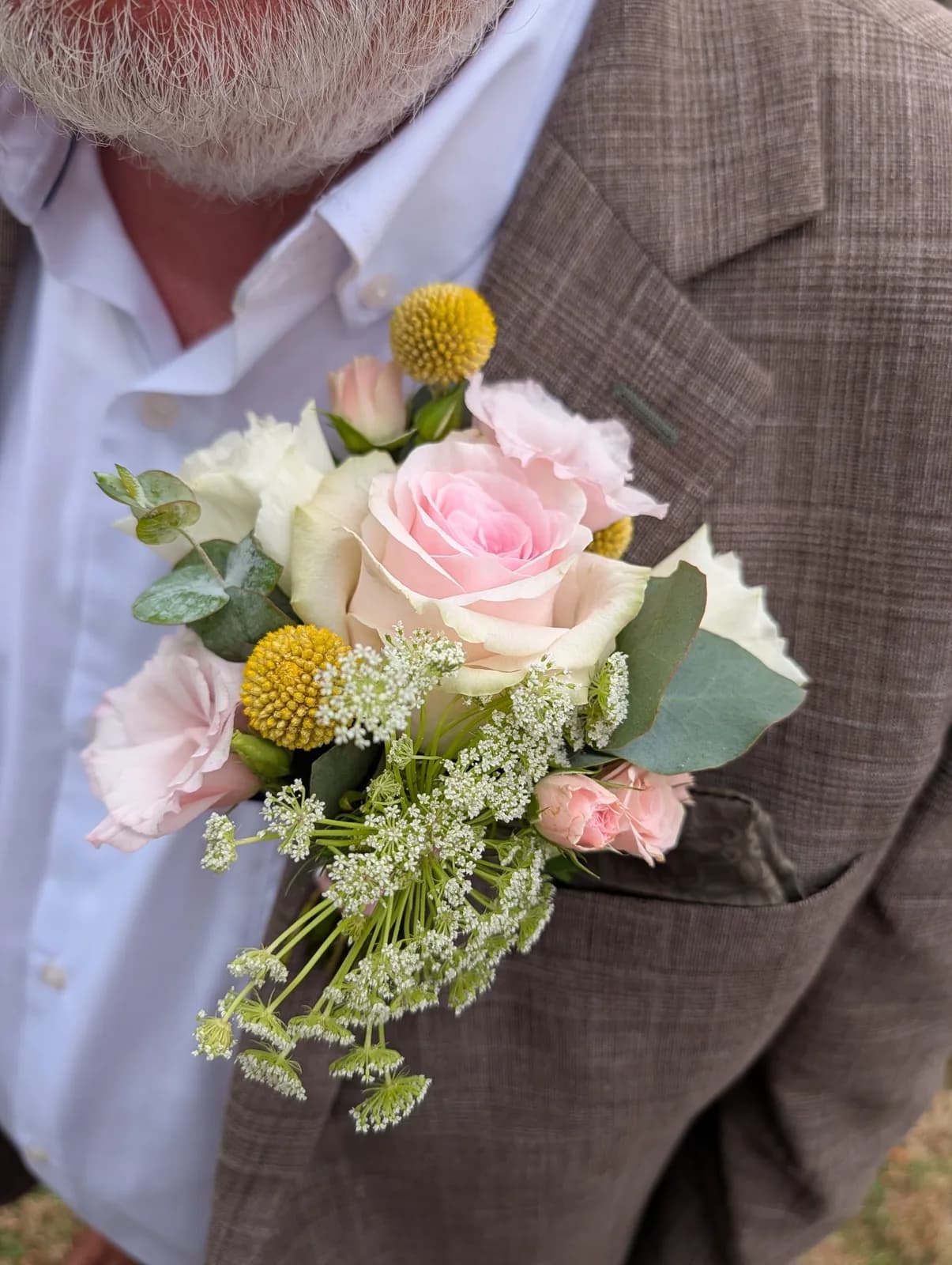 A close view of a pink rose and yellow buttonhole