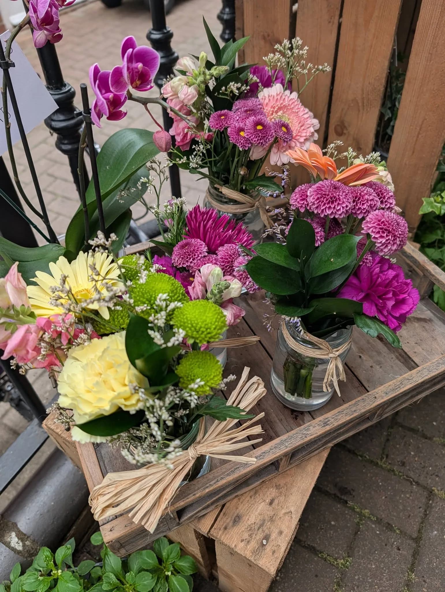 Colourful flowers arranged in small glass jars